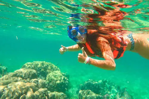 Young woman posing to the camera while snorkeling