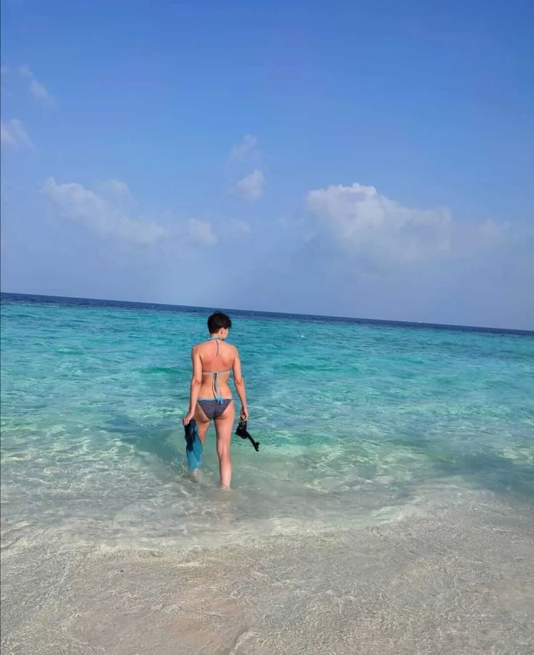 Mujer entrando al mar con sus aletas y máscara de buceo | Cancun Snorkeling