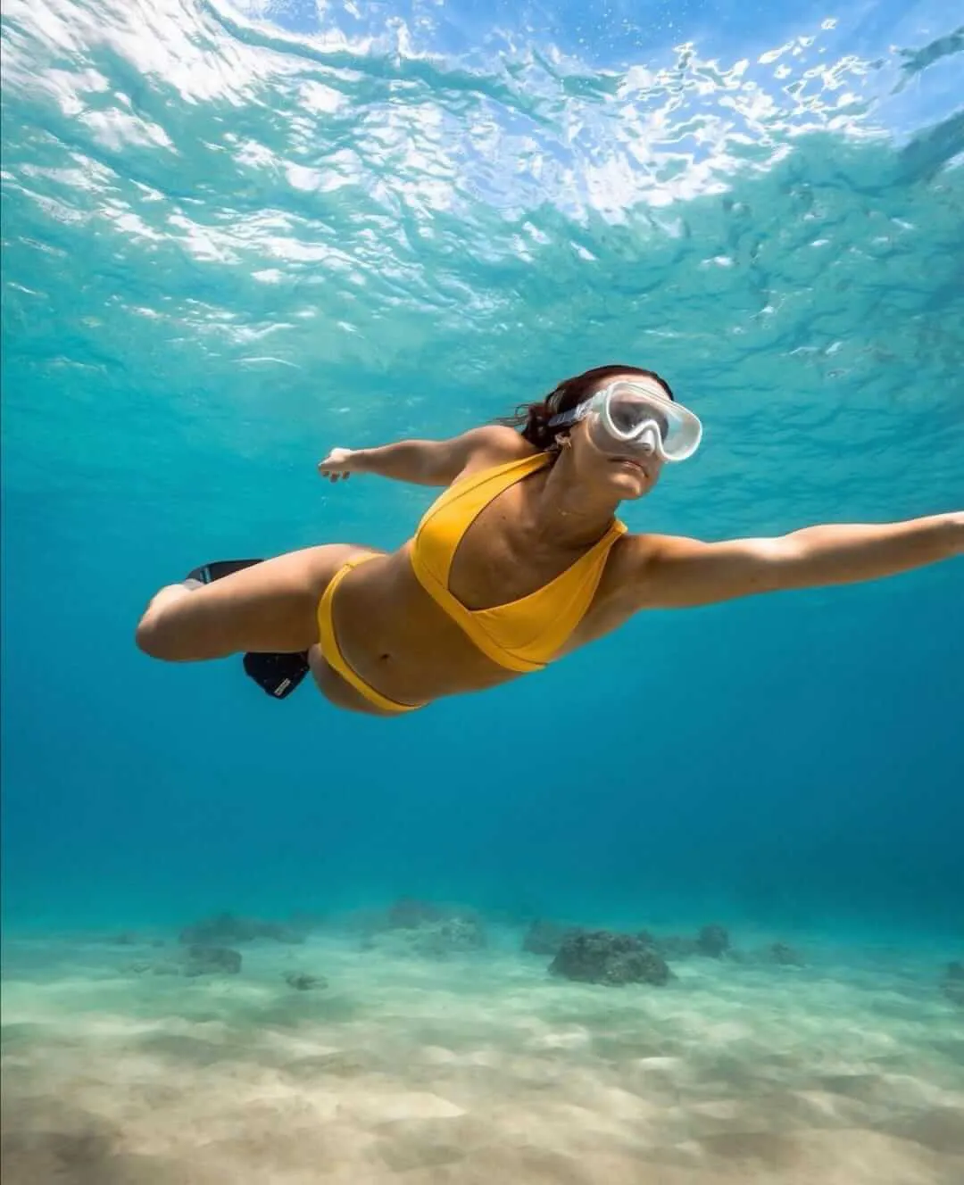 Mujer usando traje de baño amarillo haciendo snorkeling sin un tubo para respirar | Cancun Snorkeling