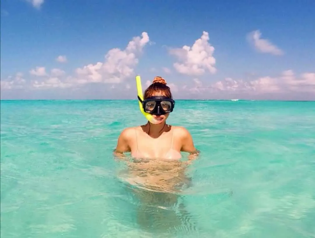 Standing snorkeler woman in the sea around turquoise waters