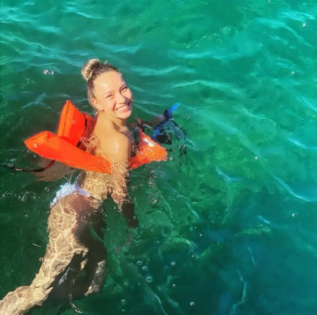 Mujer sonriendo a la cámara mientras usa un chaleco salvavidas lista para hacer snorkel | Cancun Snorkeling
