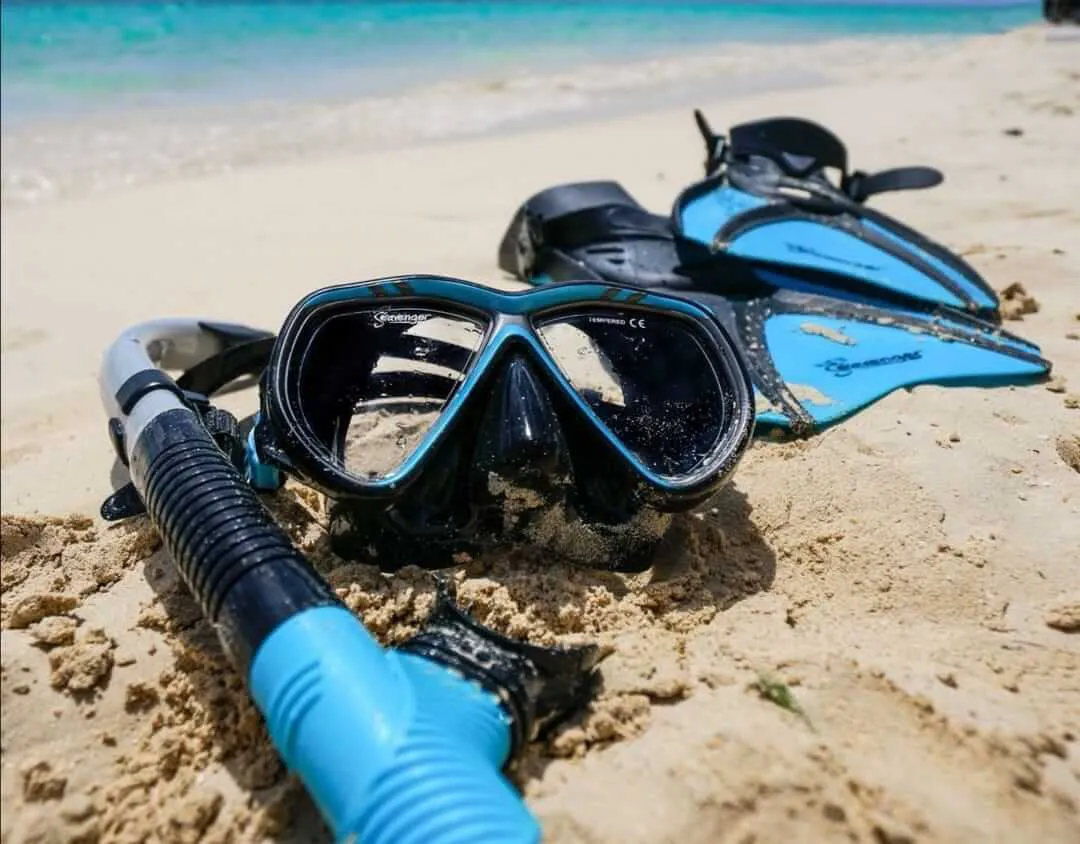 Snorkeling mask, tube and fins on the sand about the sea 
